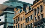 Historic townhouses contrast with the curved glass façade and rooftop terrace of Brucity, the City of Brussels’ administrative centre on Rue des Halles.