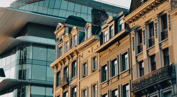 Historic townhouses contrast with the curved glass façade and rooftop terrace of Brucity, the City of Brussels’ administrative centre on Rue des Halles.