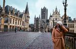 Bezoeker op de Sint-Michielsbrug met historische gebouwen in Gent op de achtergrond.