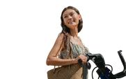 A smiling young woman standing next to an e-bike.