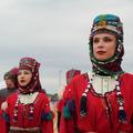 Mensen in traditionele klederdracht tijdens een cultureel evenement.