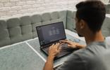 Persoon werkt op een laptop met een digitale interface op het scherm.